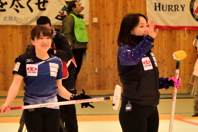 観客に手を振るカーリング選手