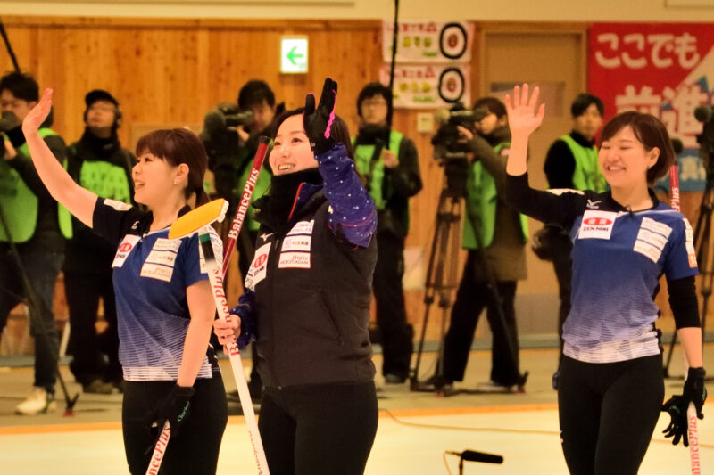 笑いながら手を振る三人の女性