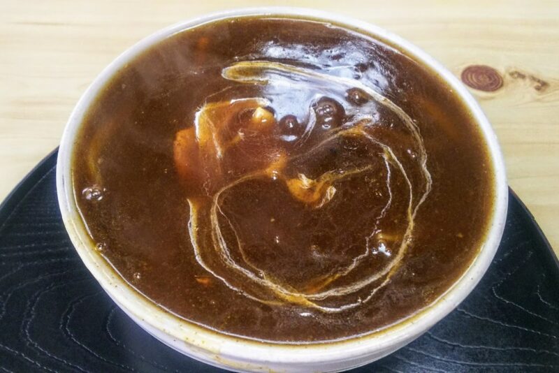 いっぱいにスープが注がれたカレーそば