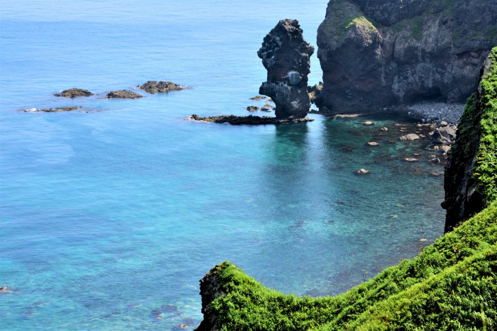 突き出た岩と岸壁と青い海